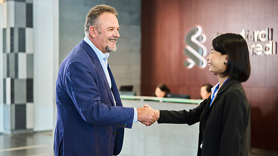 A member of staff greets a government employee.