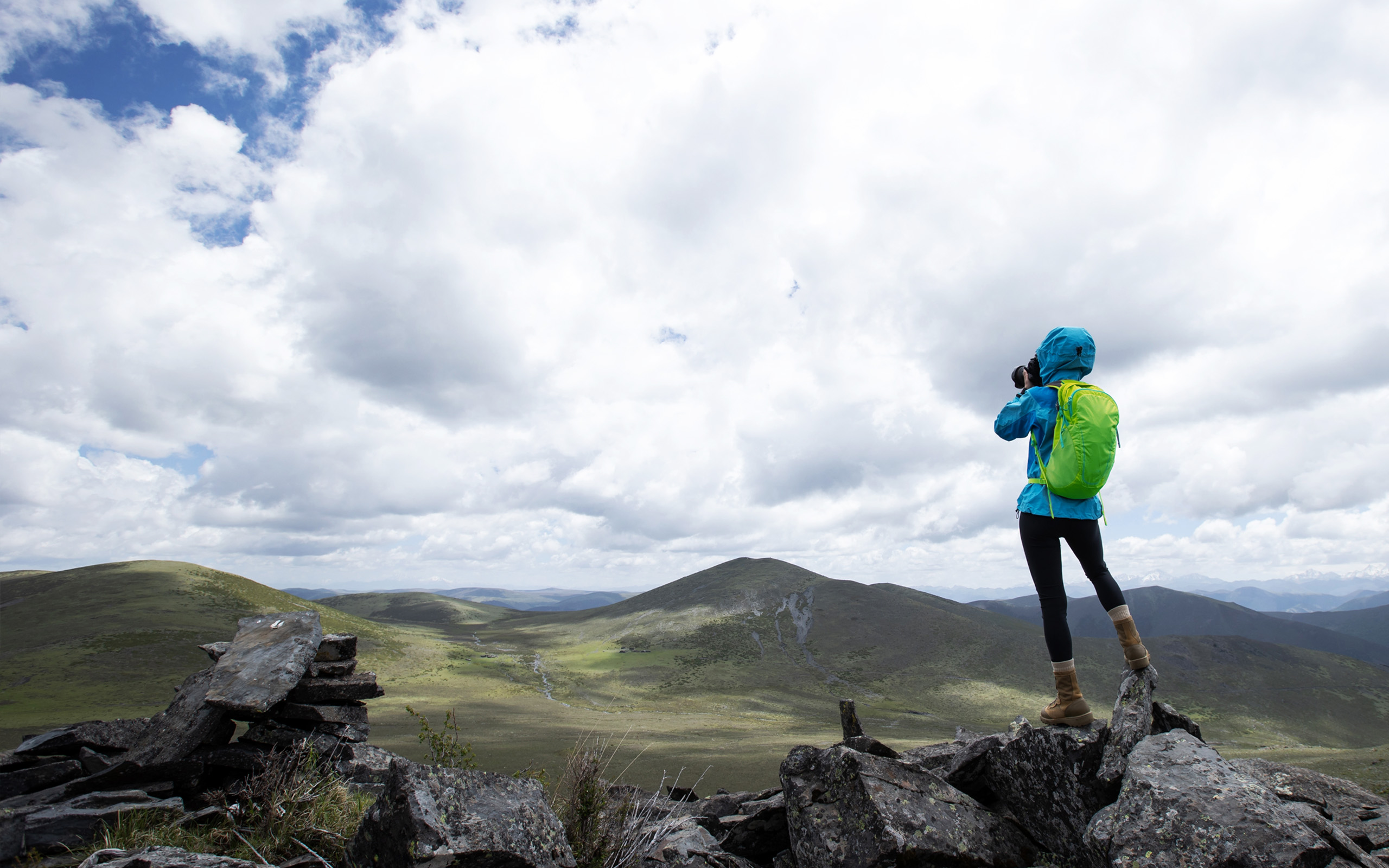 a photographer stands on a rocky hilltop