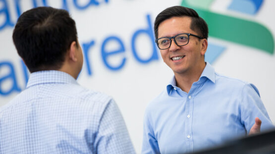 Two men discussing capital and securities at Standard Chartered Bank