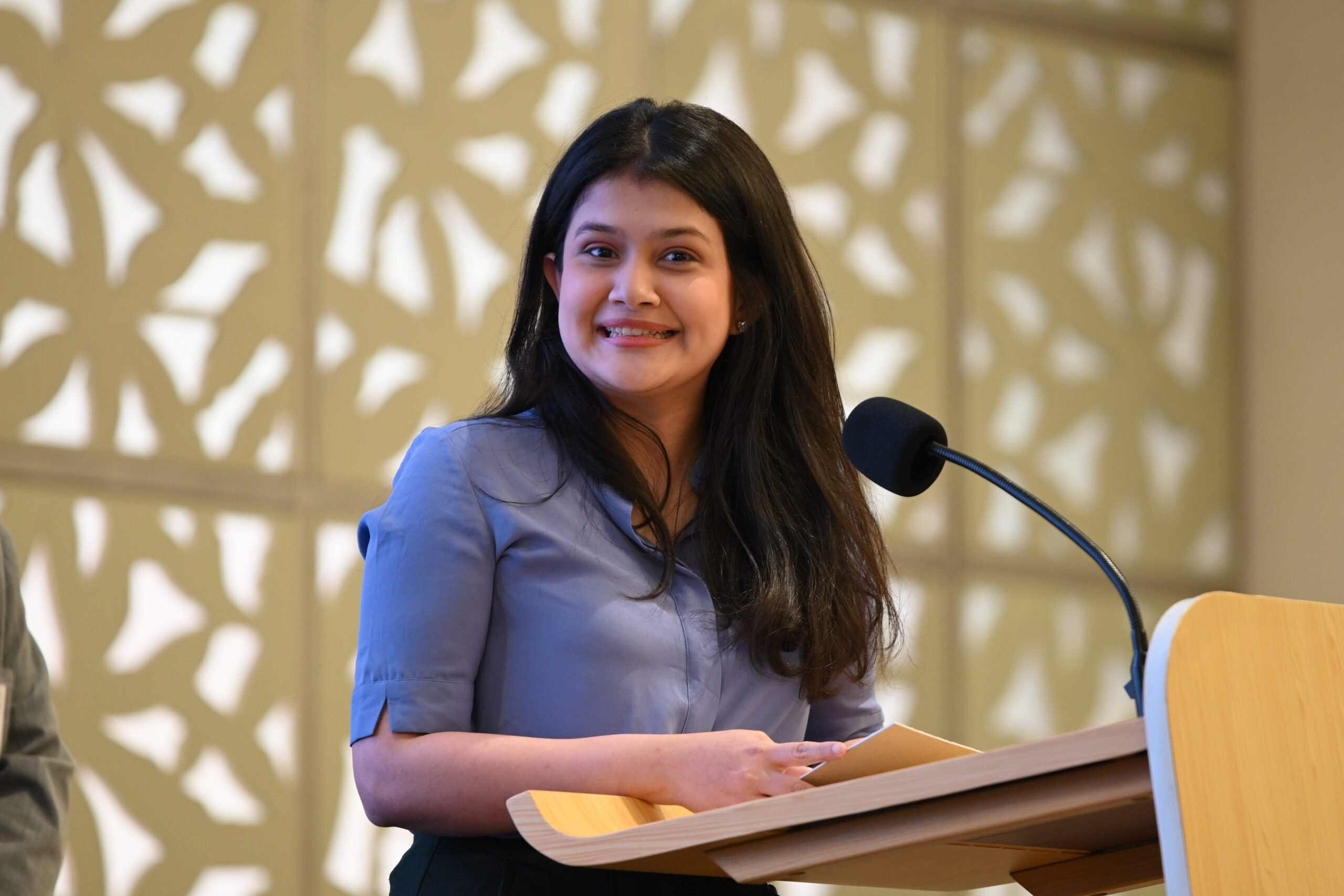 A smiling girl talking over the microphone