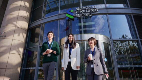 Colleagues outside an office with a bilingual sign.