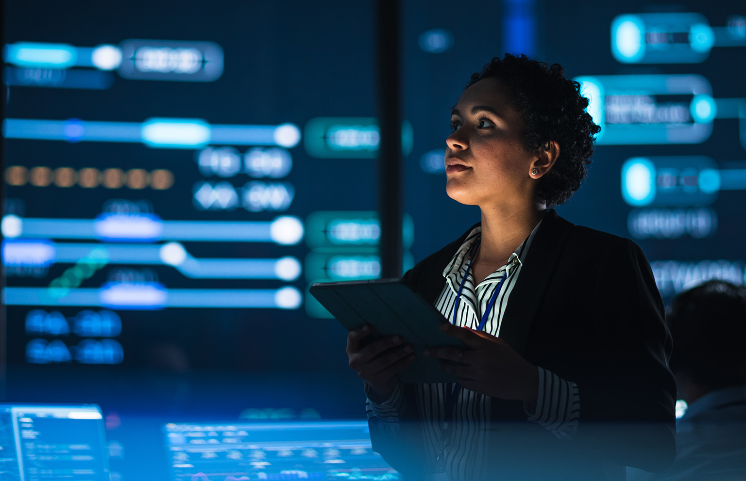 A data engineer reviews infrastructure using an iPad.