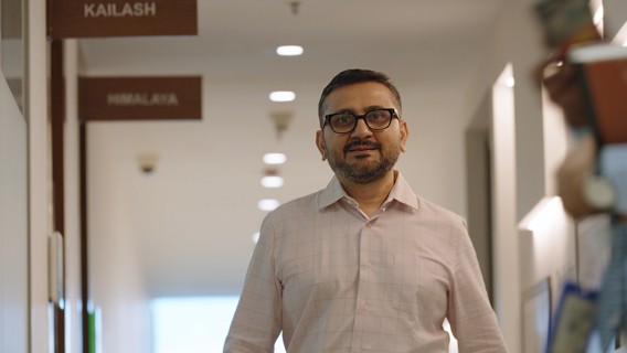 A person with glasses and a white shirt walking 
