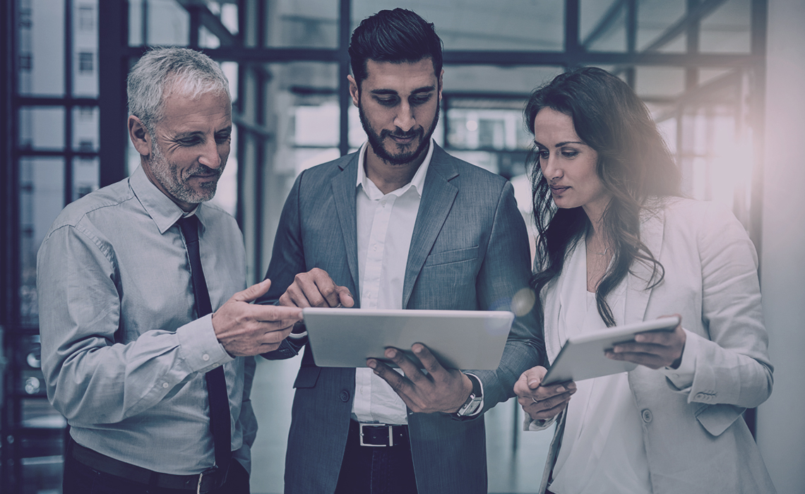 Three people looking at a tablet