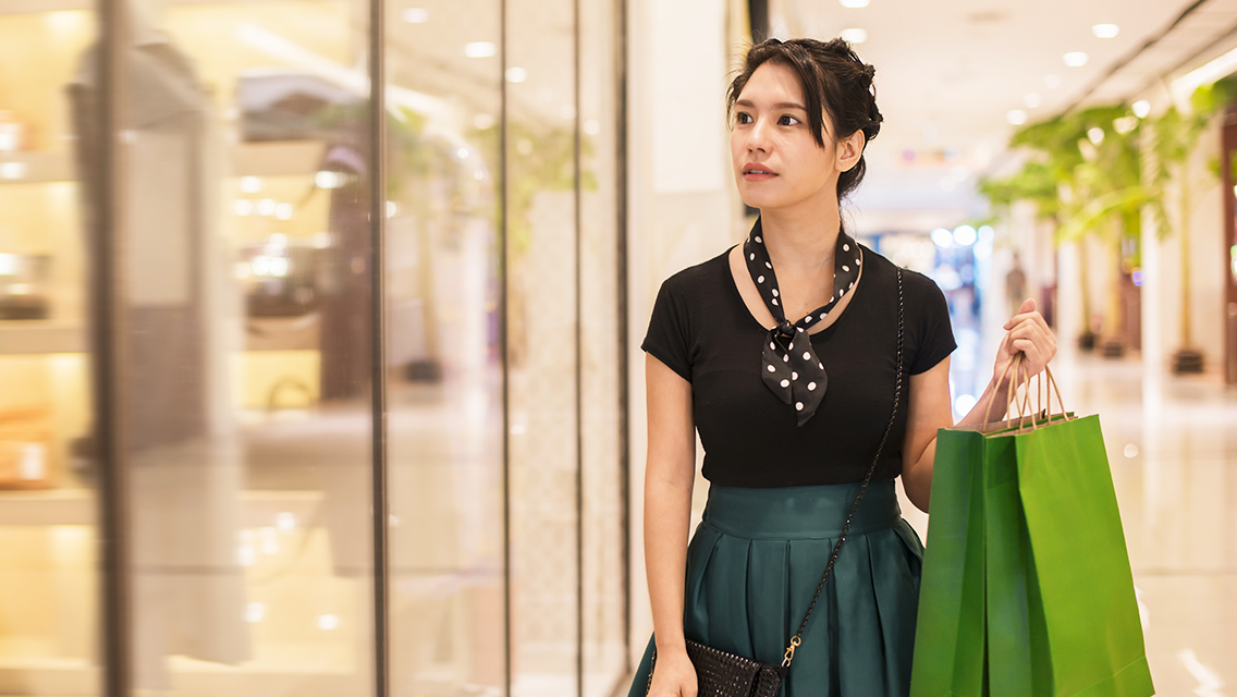 Woman shopping for clothes in a mall.