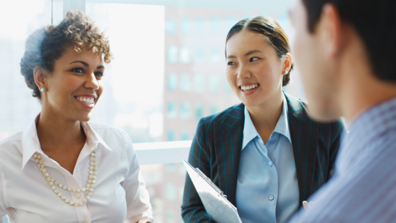 A group of colleagues smile and laugh together.