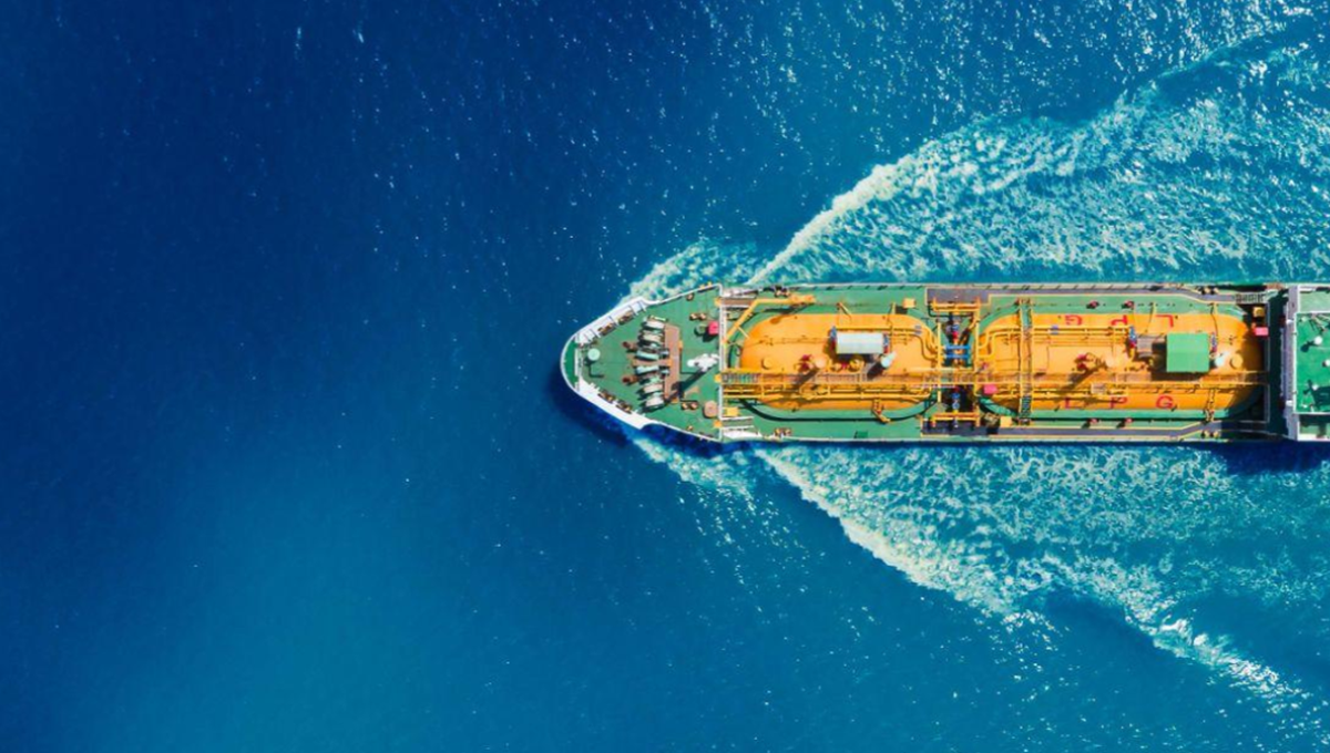 A ship carrying shipping containers cruises through the sea,