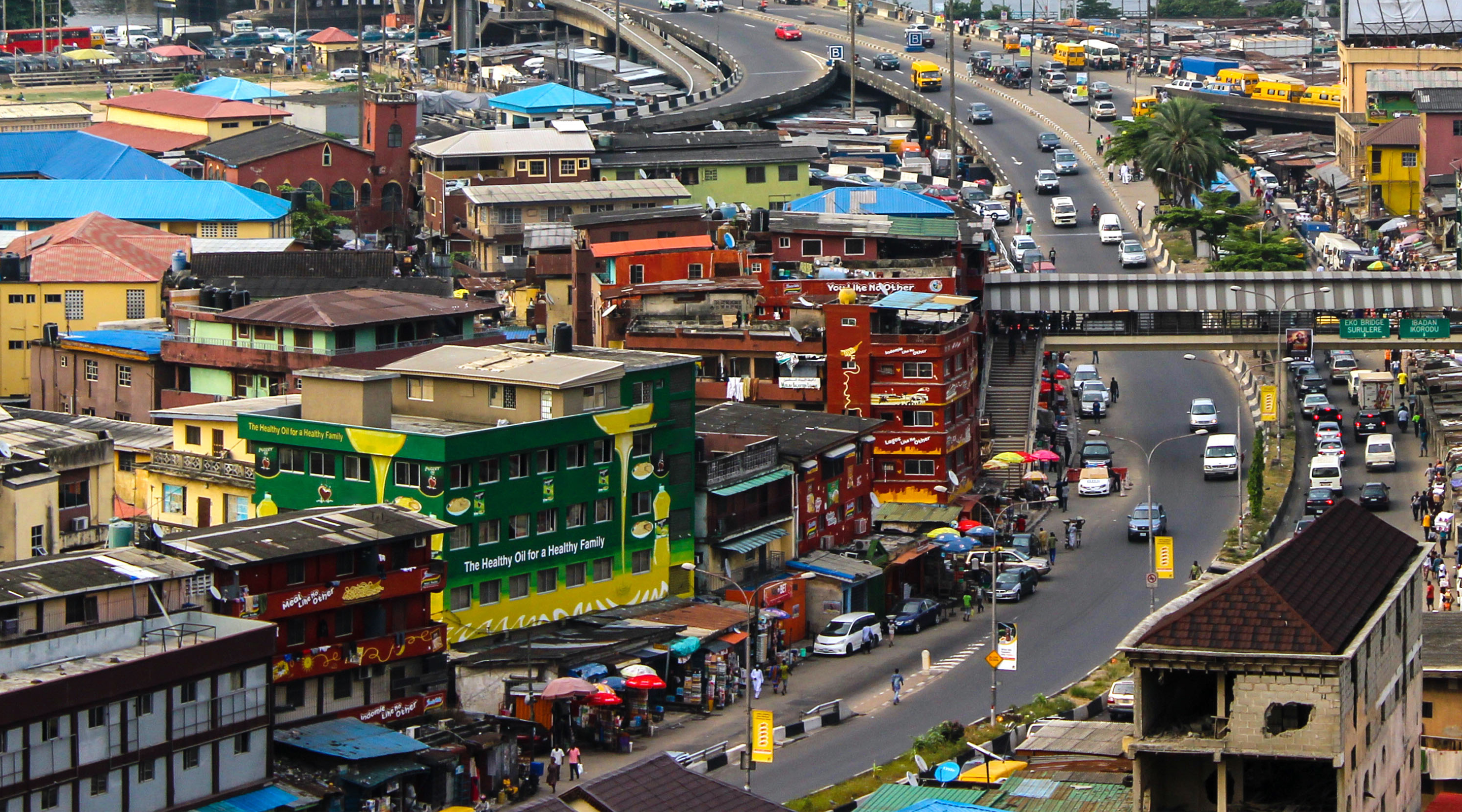 A busy urban landscape with shops, building work, roads and warehouses.